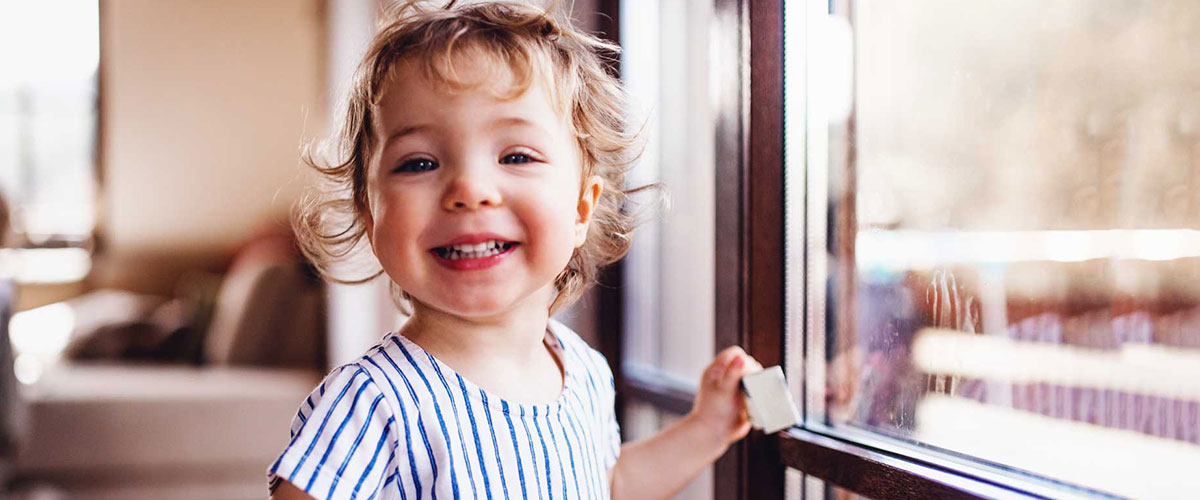 Child smiling and looking out of the window.